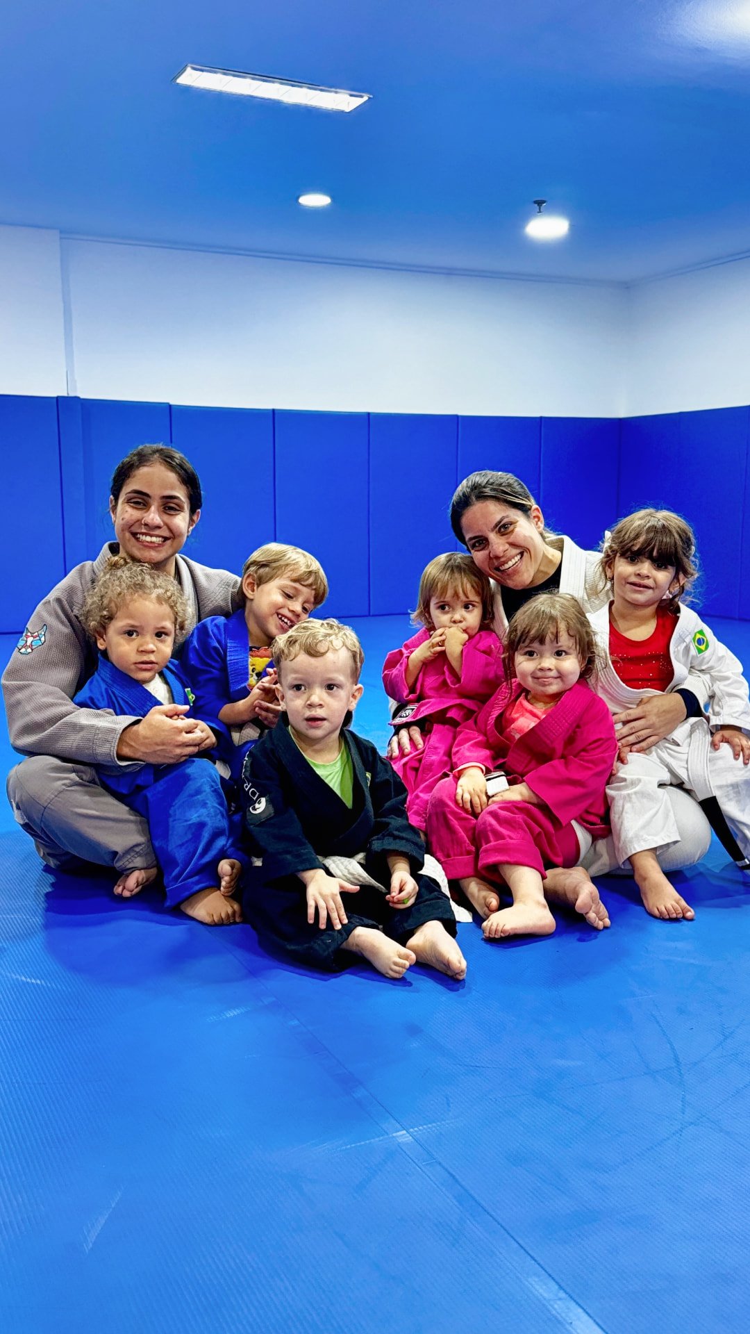 Professoras e crianças da turma de 2 anos reunidas no tatame da Atlas